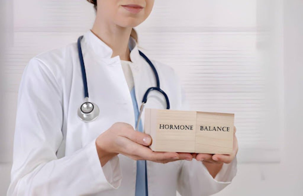 A doctor holding wooden blocks labeled hormone balance during a man’s hormone therapy consultation.